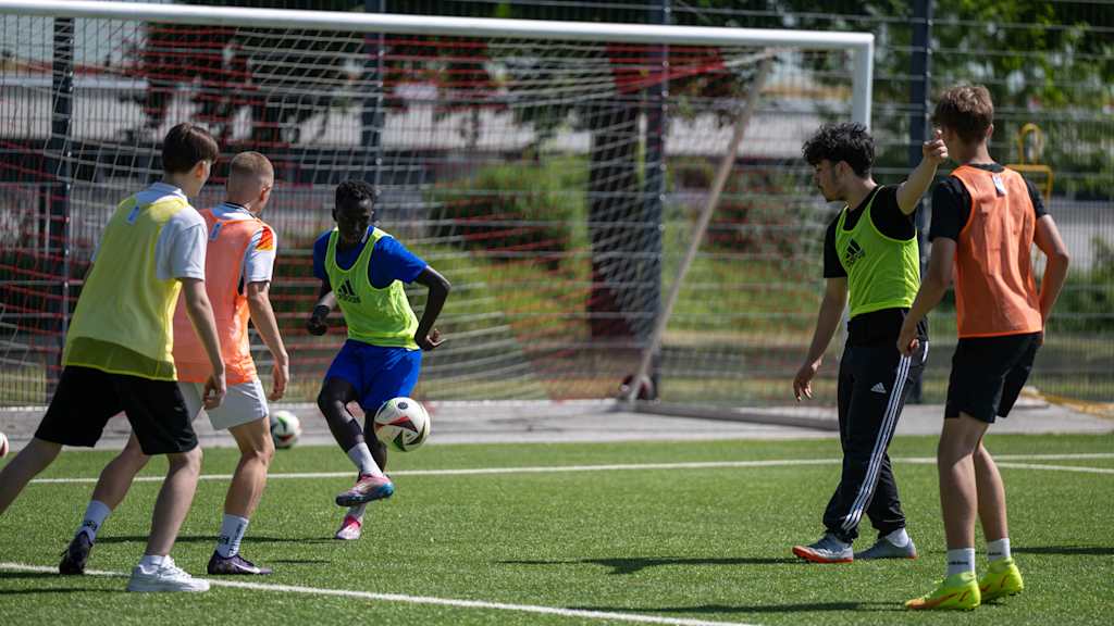 Jugendliche kicken auf einem Platz am FC Bayern Campus