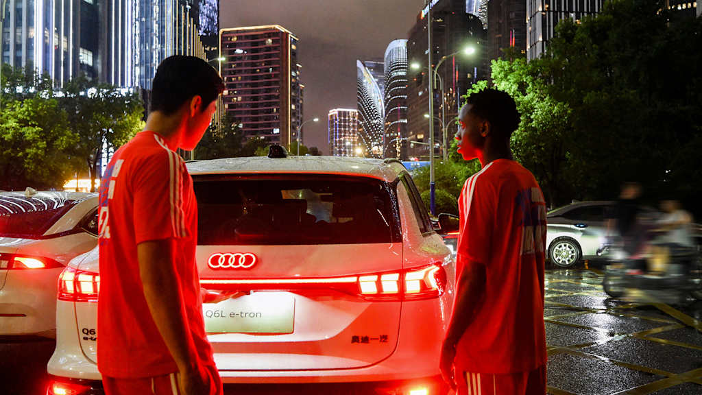Zwei Spieler des World Squad stehen vor einem Audi