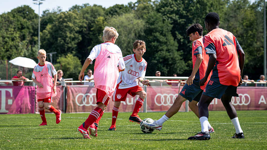 Un jugador del FC Bayern World Squad 2025 juega al fútbol con los niños