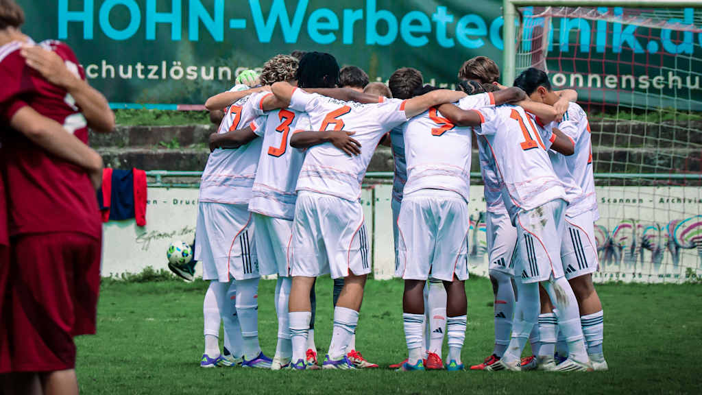 Teamkreis der U17 auf dem Rasen.