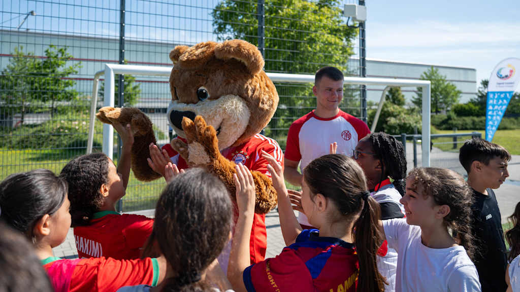 Maskottchen Berni mit den Kindern am FC Bayern Campus.
