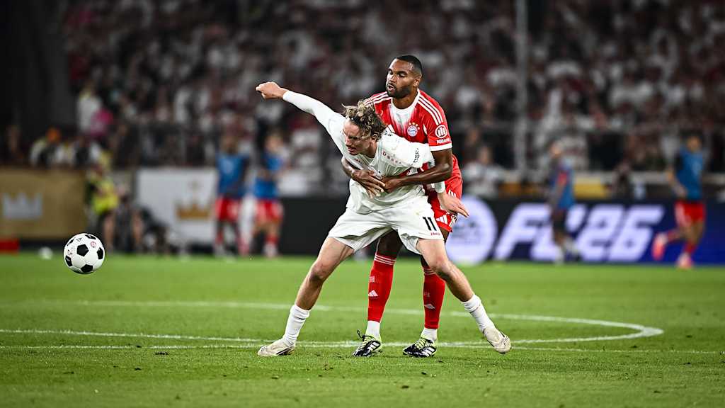 Jonathan Tah grapples with Nick Woltemade during the Franz Beckenbauer Supercup against Stuttgart