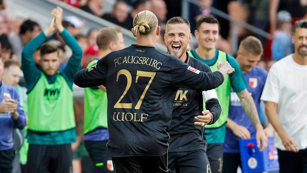 Marius Wolf und Jeffrey Gouweleeuw bejubeln ein Tor des FC Augsburg.