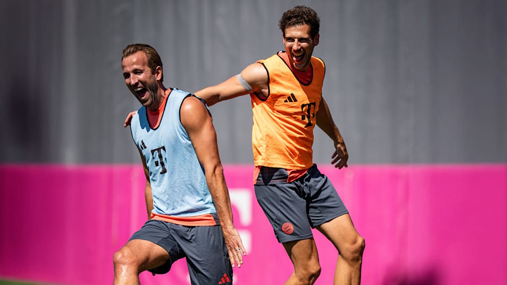 Harry Kane und Leon Goretzka lachend beim Warmlaufen im Training des FC Bayern vor dem Pokalspiel in Wiesbaden.