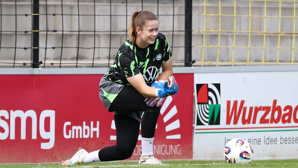 Stina Johannes rollt den Ball kniend beim aufwärmen vor einem Spiel ins Feld.