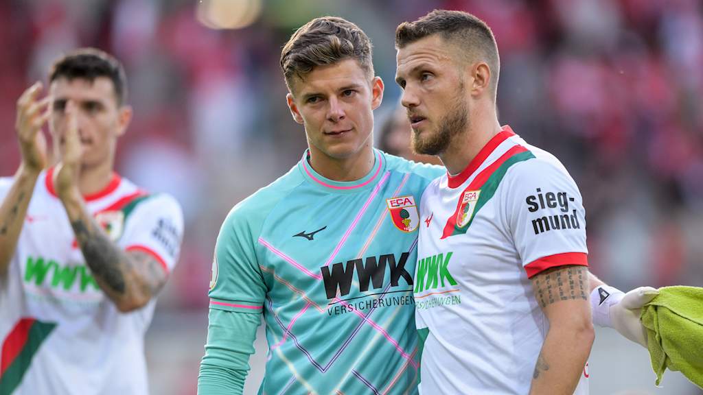 Finn Dahmen und Jeffrey Gouweleeuw sprechen nach einem Spiel des FC Augsburg.