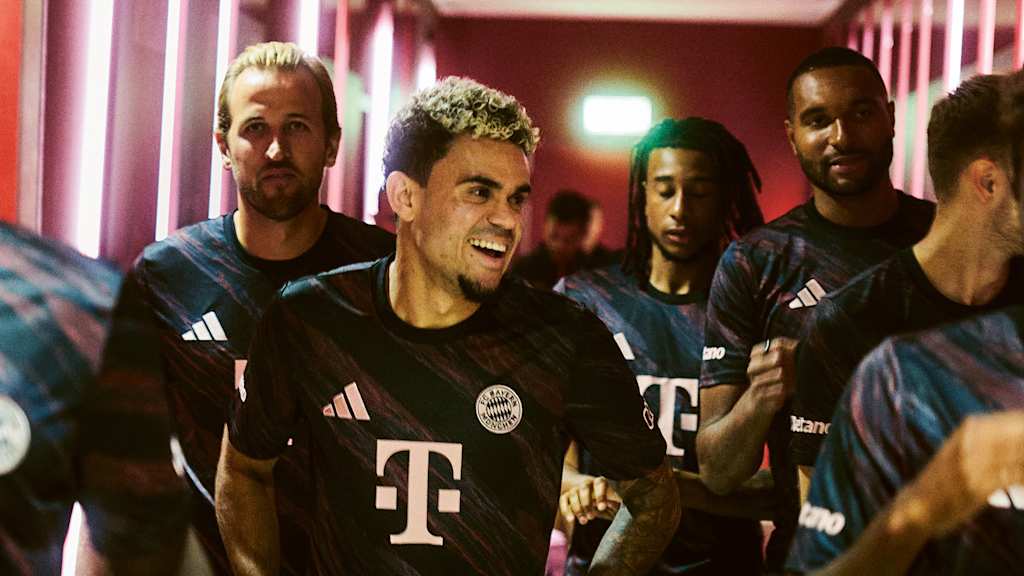 Luis Díaz lachend mit den Teamkollegen auf dem Weg aus der Kabine der Allianz Arena zum Platz.