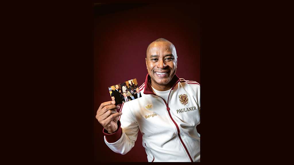 Paulo Sergio holds a framed picture of Franz Beckenbauer in his hand.