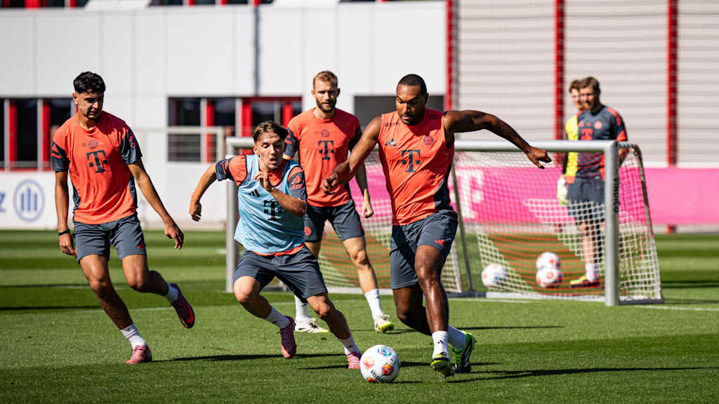 Jona Tah im orangenen Oberteil im FC Bayern-Training im Zweikampf mit Lenny Karl