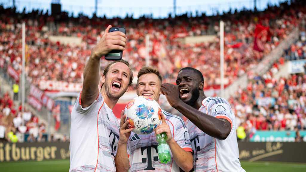 Harry Kane, Joshua Kimmich und Dayot Upamecano machen vor dem Gästeblock in Sinsheim ein Selfie.