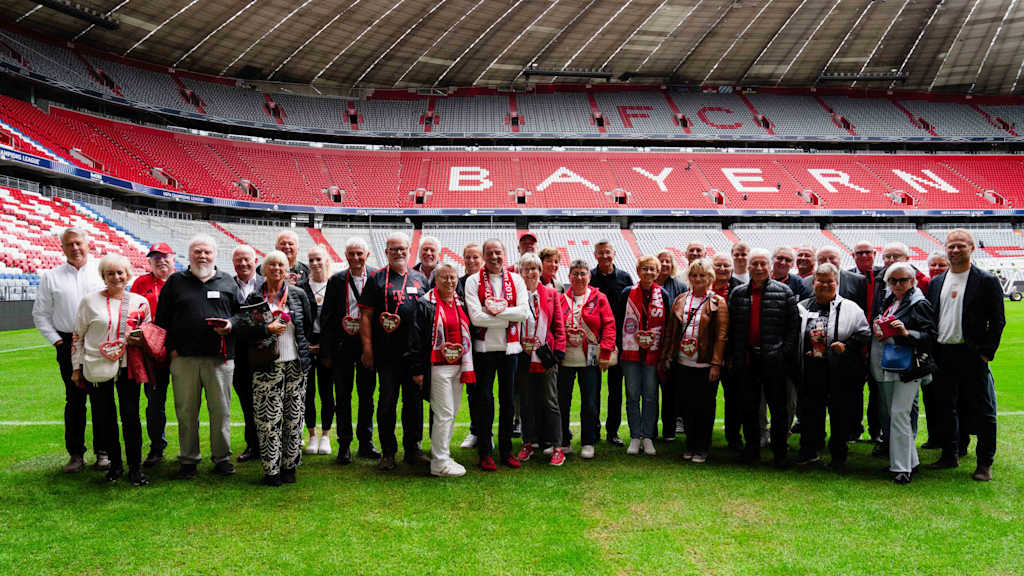 Eine Gruppe steht auf dem Rasen der Allianz Arena bei einer Arena-Tour.