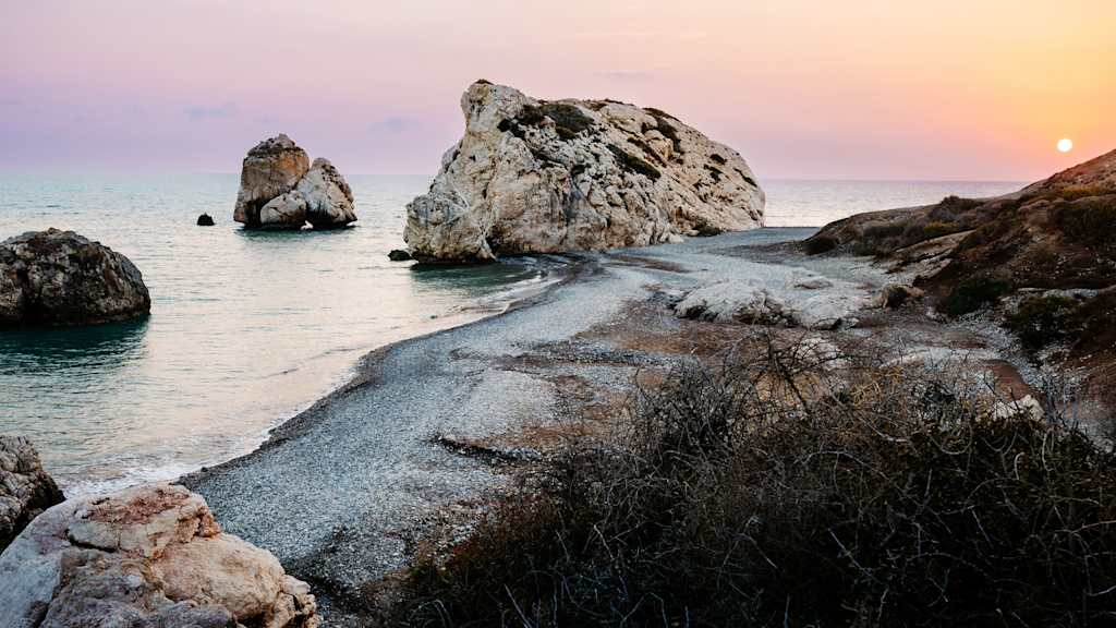 Abendstimmung am Strand in Zypern mit dem Blick auf einen malerischen Felsen in der Bucht