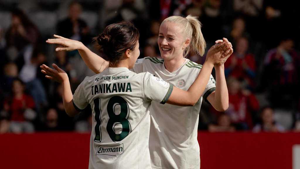 Tanikawa und Schüller klatschen sich nach einem Tor ab und lächeln.