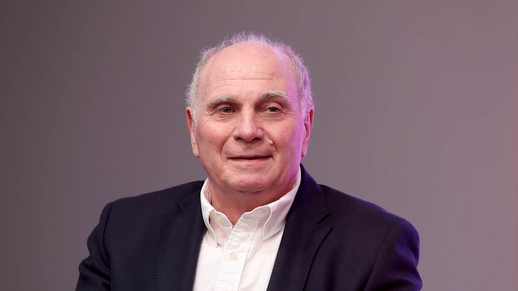 Uli Hoeneß lächelt im Anzug in die Kamera