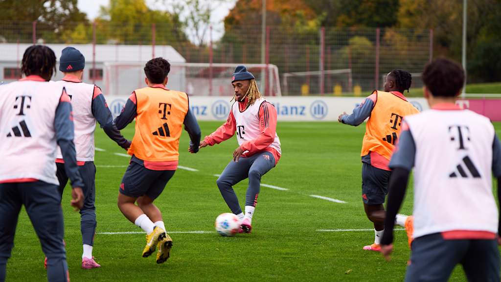 Sacha Boey im Training des FC Bayern umringt von Gegenspielern.