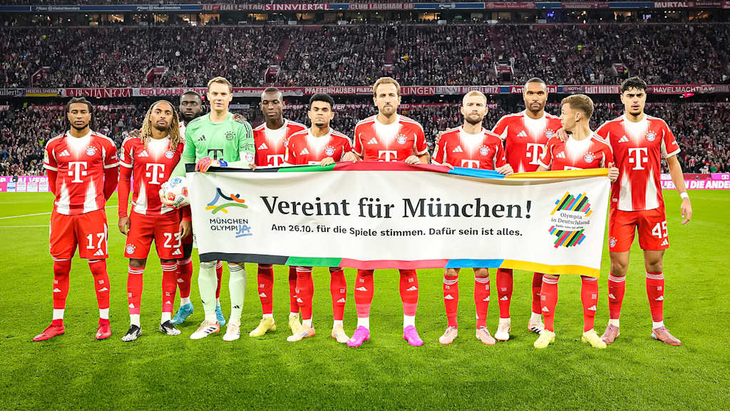 Die Mannschaft des FC Bayern hält einen Banner anlässlich Münchens Bewerbung für die Olympischen Sommerspiele