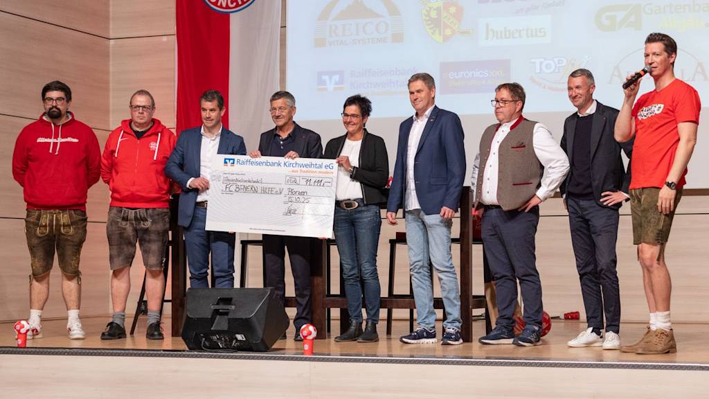 Präsident Herbert Hainer mit Fans und Spendenscheck auf dem Fanclub-treffen