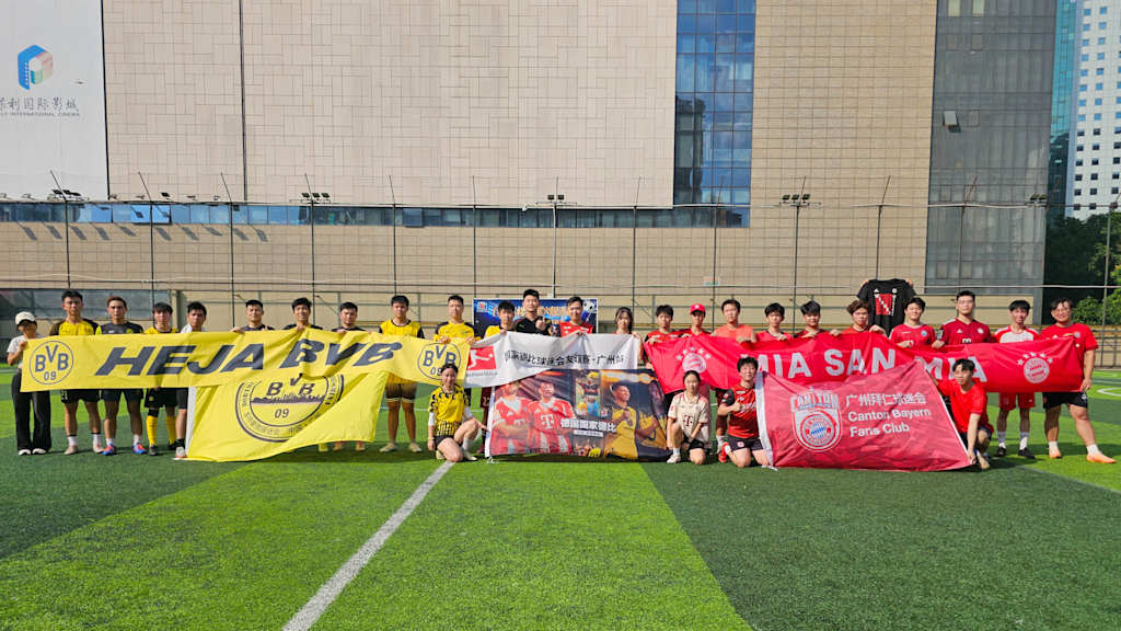Auf einem Platz in Guangzhou stehen sich die Fanclubs des FC Bayern und des BVB gegenüber.