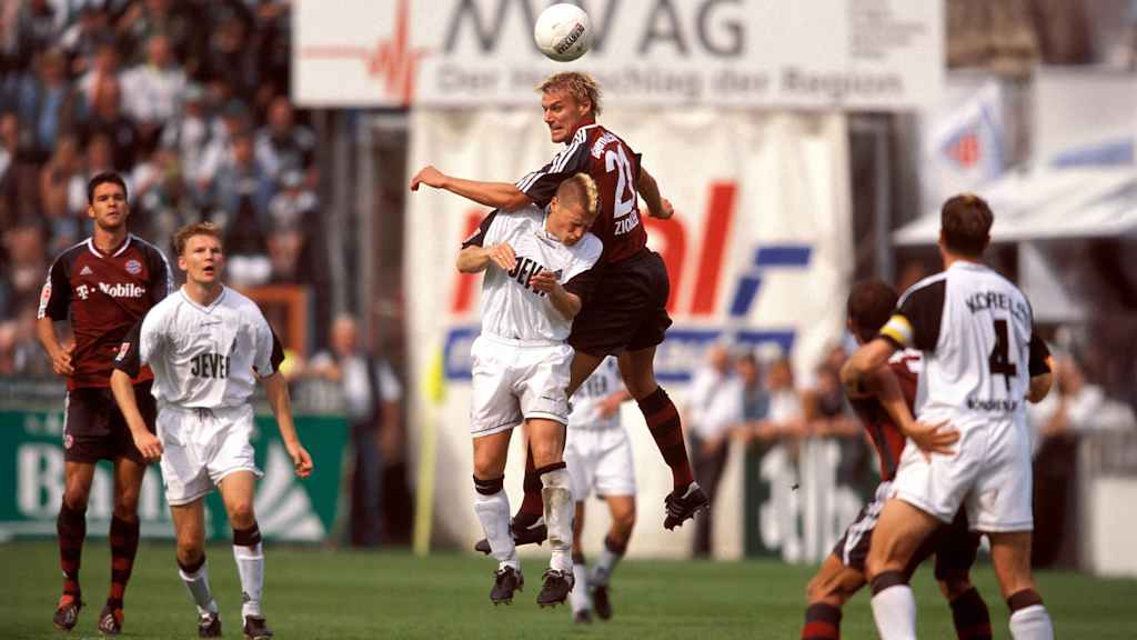 Max Eberl im Gladbach-Trikot im Luft-Zweikampf mit Alexander Zickler im Bayern-Trikot.