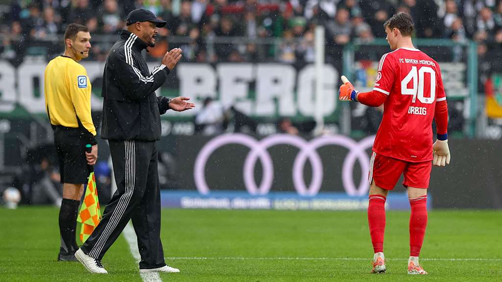 Trainer Vincent Kompany spricht mit Torwart Jonas Urbig im Bundesliga-Spiel des FC Bayern bei Borussia Mönchengladbach.
