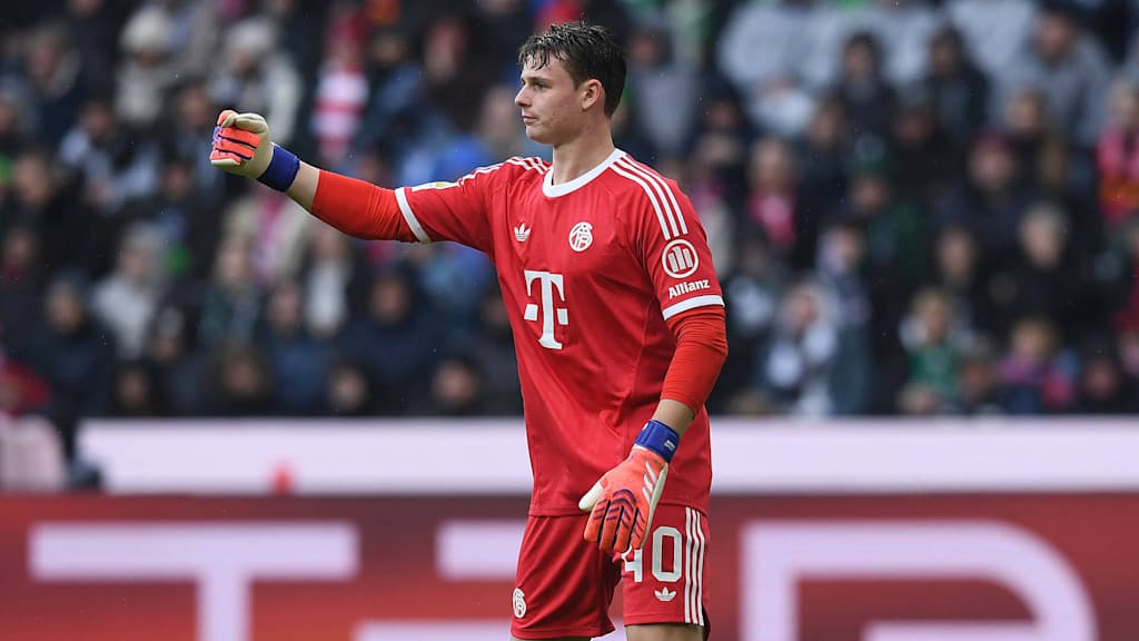 Jonas Urbig im roten Torwarttrikot des FC Bayern in der Partie gegen Mönchengladbach