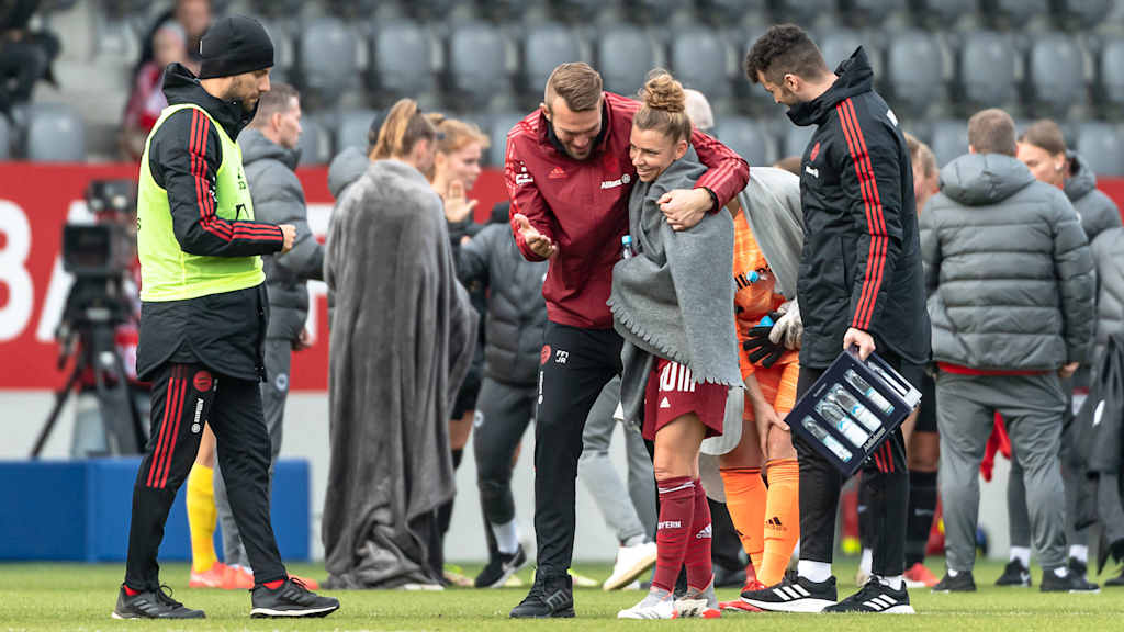 Jérôme Reisacher umarmt Linda Dallmann nach einem Heimspiel der FC Bayern Frauen.