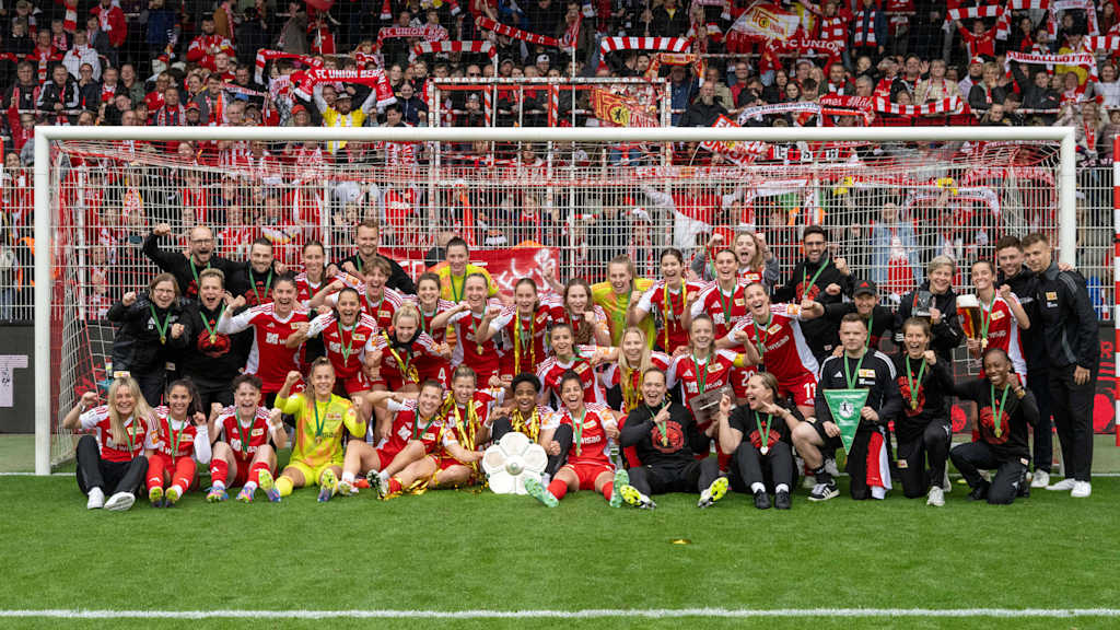 Die Union Berlin-Frauen feiern vor der Kurve den Aufstieg in die Bundesliga.