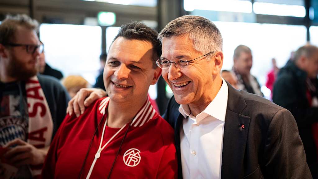 Herbert Hainer hält ein Mitglied des FC Bayern im Arm