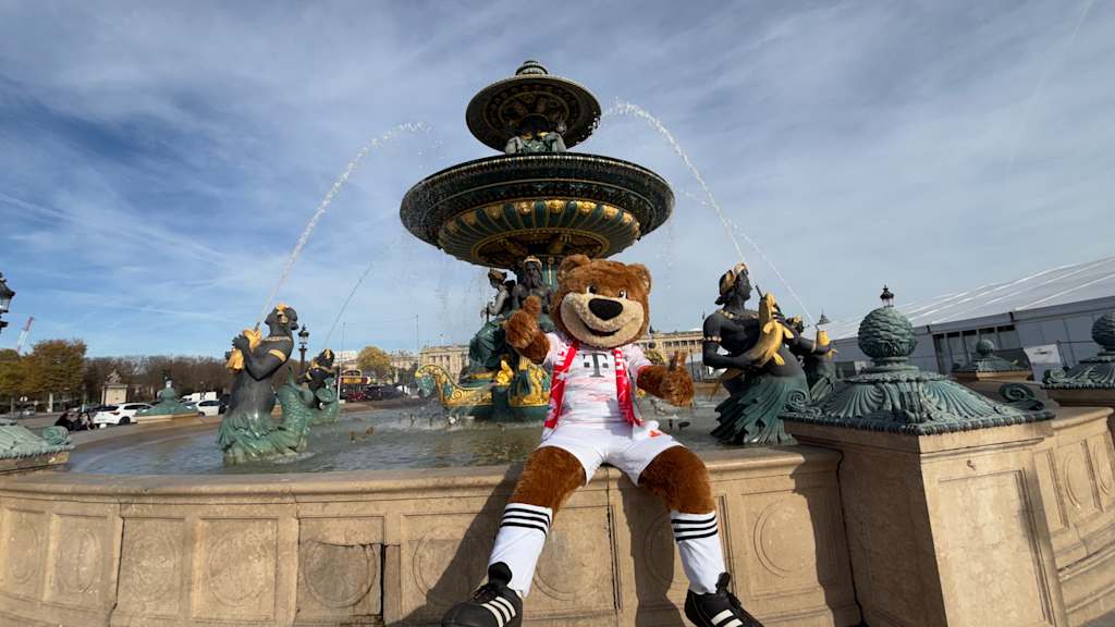 Berni sitzt in Paris auf einem Brunnen.