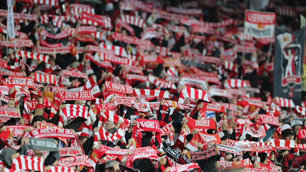 Fans von Union Berlin halten Schals in die Höhe.