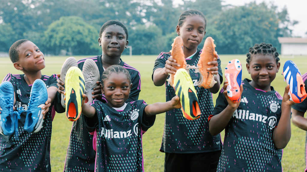 Fußballerinnen aus Kamerun zeigen ihre neuen Schuhe in die Kamera