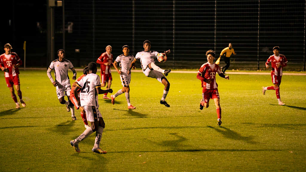 Zwei Nachwuchsteams bestreiten unter Flutlicht ein Fußballspiel