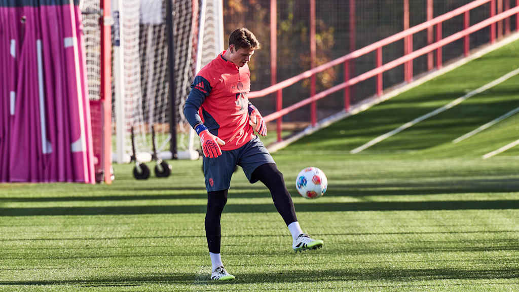 Jonas Urbig jongliert den Ball in der FC Bayern-Teamline.