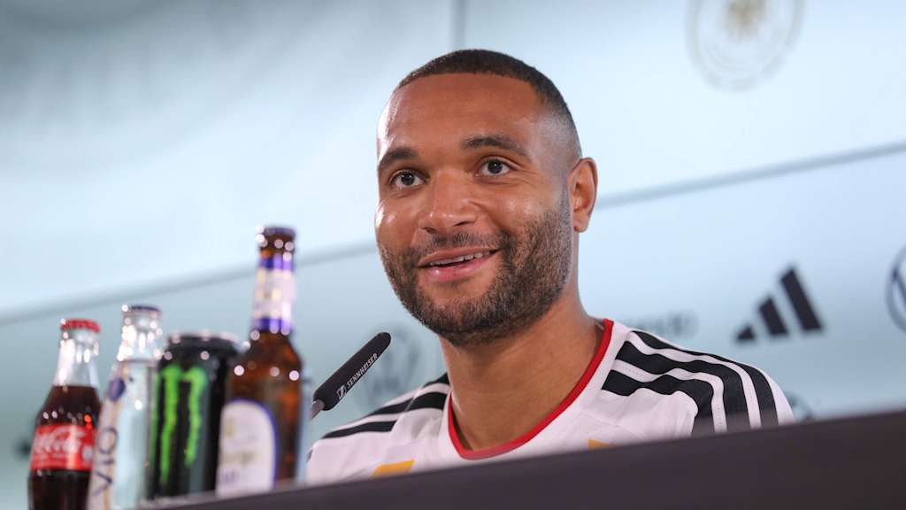 Jonathan Tah sitzt im weißen Shirt des DFB-Teams auf der Pressekonferenz