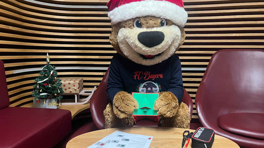 Berni an einem Tisch, während er eine Weihnachtskarte bastelt.