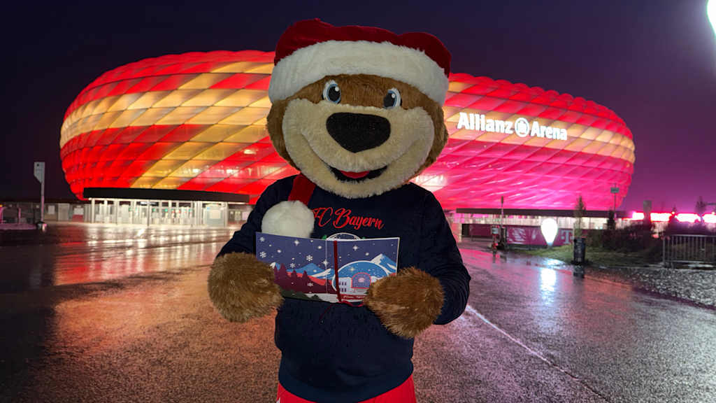 Berni mit einem Liederbuch in der Hand vor der Allianz Arena.
