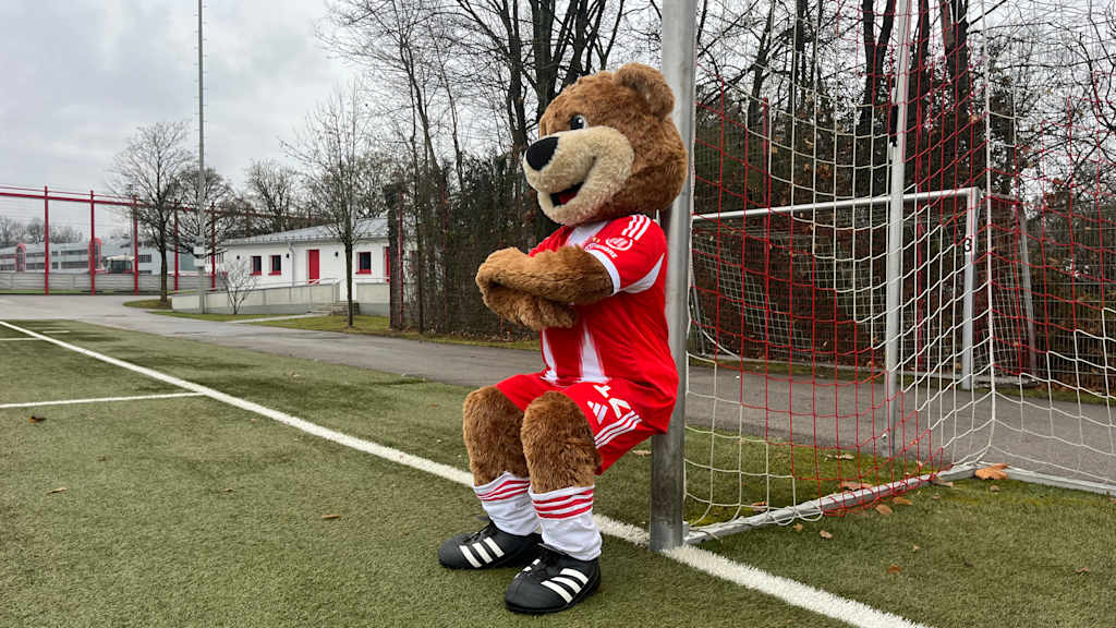 Berni macht Wandsitzen mit dem Rücken am Torpfosten.