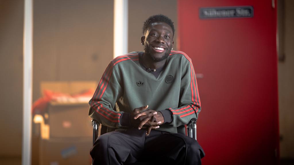 Alphonso Davies sits in a TV studio for his interview for the documentary "Alphonso Davies - Doors of life"