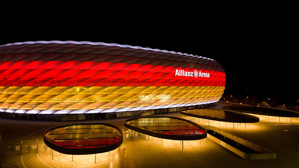 Die Münchner Allianz Arena bei Nacht in den Farben schwarz, rot und gold.