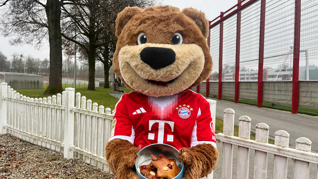 Berni sitzt draußen auf einem Stuhl und präsentiert seine Lebkuchen in einer Dose.