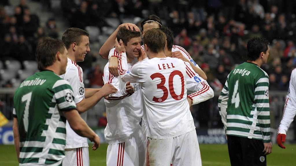 Thomas Müller jubelt im weißen Trikot 2009 gegen Sporting mit Podolski und Lell.