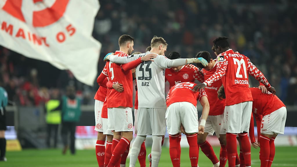 The FSV Mainz 05 players stand together in a circle before kick-off