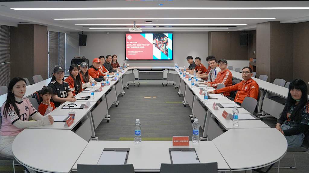 An einem Konferenztisch in Chengdu in China sitzen 14 Fanclubvorsitzende zusammen
