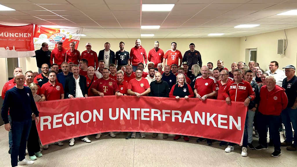 Bayernfans haben sich aufgereiht für die Kamera mit einem großen Banner "Region Unterfranken"
