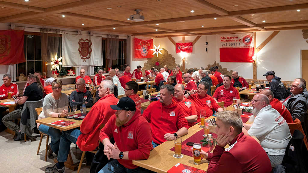 Bayernfans sitzen gemütlich in einer Stube zusammen und lauschen dem Programm
