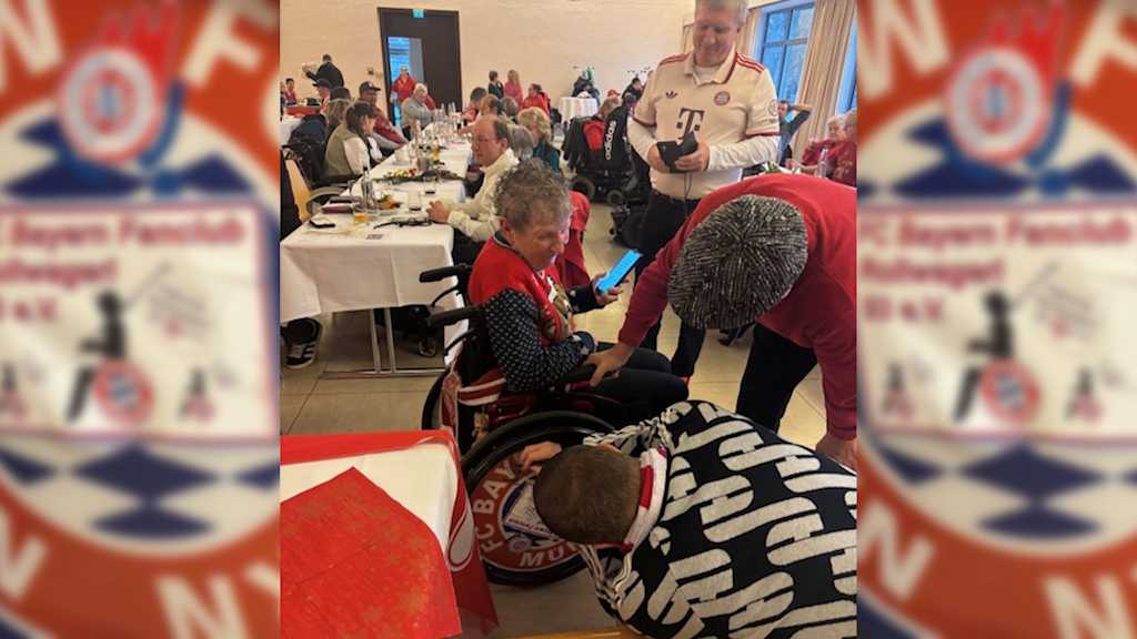 Max Eberl signs the wheelchair wheel of an FC Bayern fans