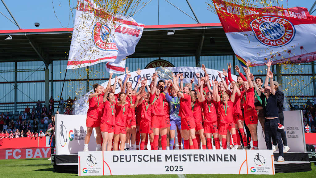 FC Bayern Frauen bekommen die Meisterschale überreicht und recken sie in die Luft.