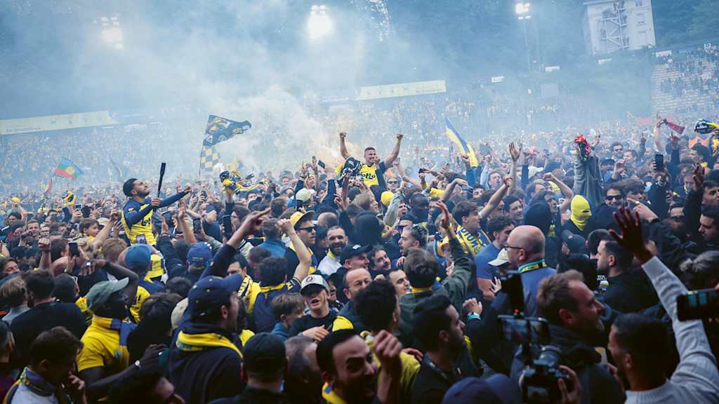 Franjo Ivanovic celebrates with fans after Union Saint-Gilloise win the title.