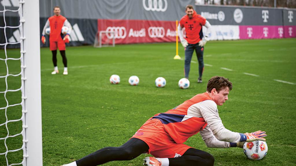 Jonas Urbig hält einen Ball im Training des FC Bayern.