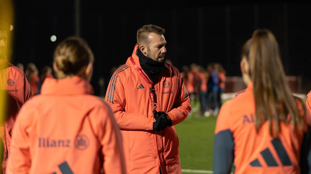 FC Bayern Frauen II-Cheftrainer Jérôme Reisacher erklärt eine Übung im Mannschaftskreis.